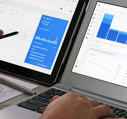 A person working on Google Analytics on two different screen